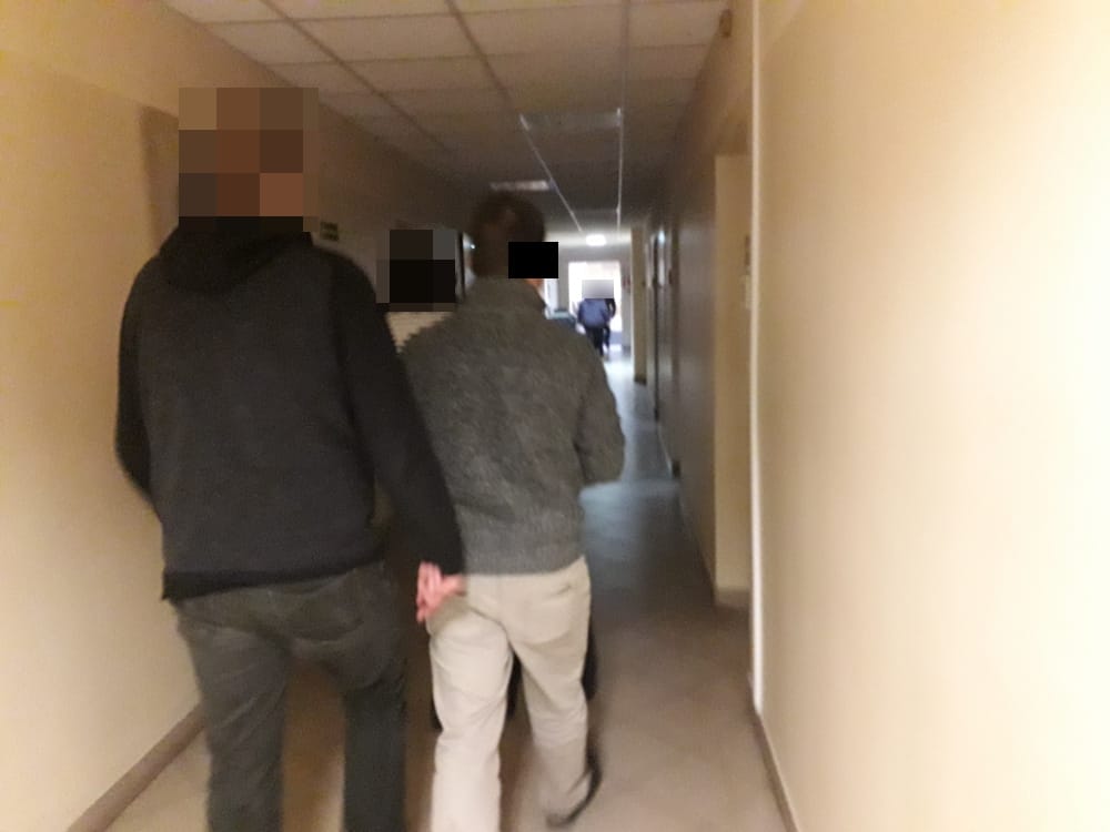 Ludzie idący korytarzem szpitala.