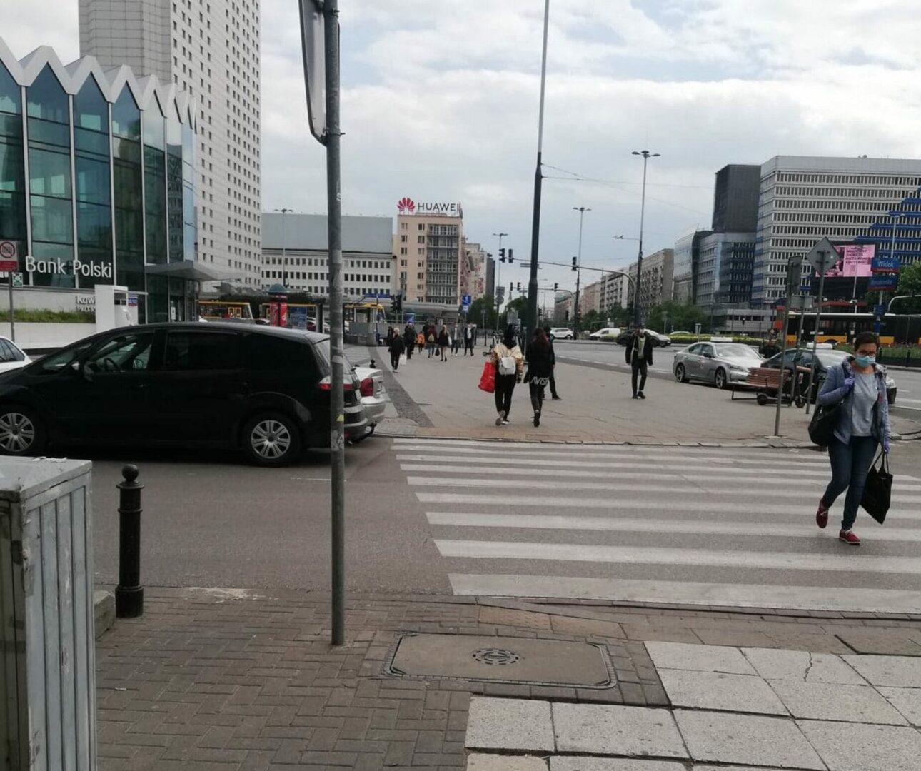 Scena uliczna w Warszawie: piesi przechodzą przez przejście dla pieszych w pobliżu Banku Polskiego.