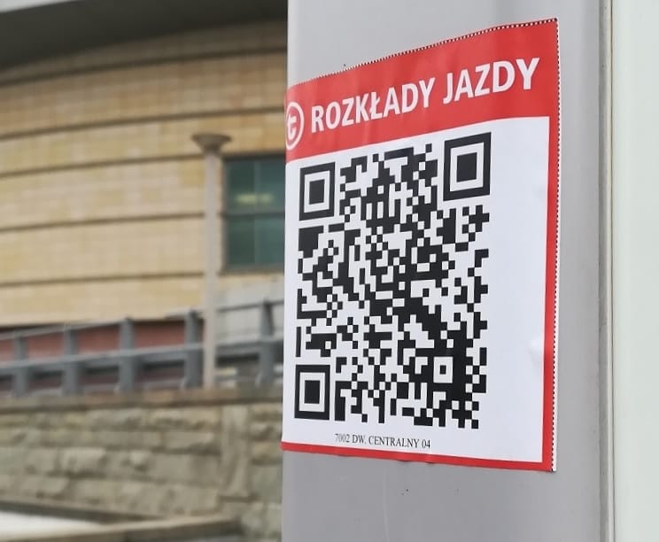 QR code for Polish train schedules (Rozkłady Jazdy) on a pole.