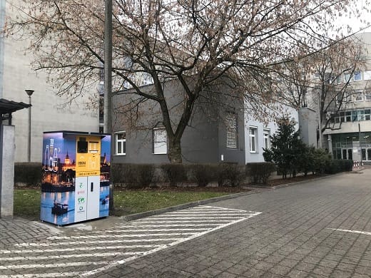 Automat do zwrotu butelek szklanych i plastikowych umieszczony przed budynkiem.