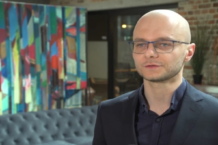 Młody mężczyzna w okularach dyskutujący o strategiach SEO.