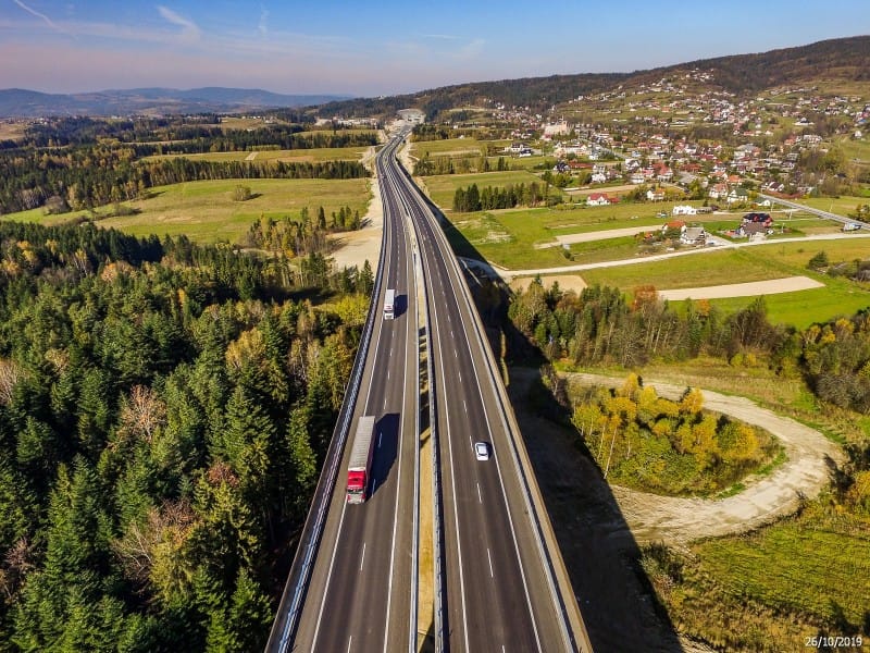 Widok z lotu ptaka na nową autostradę przecinającą wiejski krajobraz na Mazowszu. Poprawa bezpieczeństwa i zdrowia na drodze.