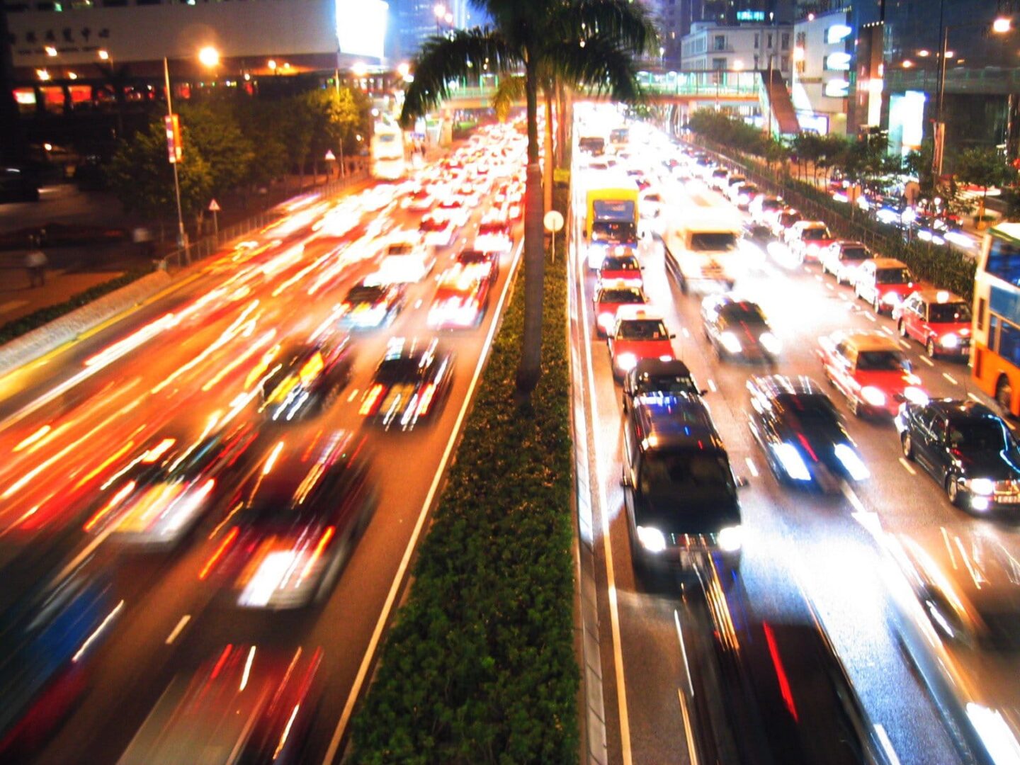 Nocny ruch na ruchliwej autostradzie miasta, rozmazany ruch ukazujący szybko poruszające się pojazdy.