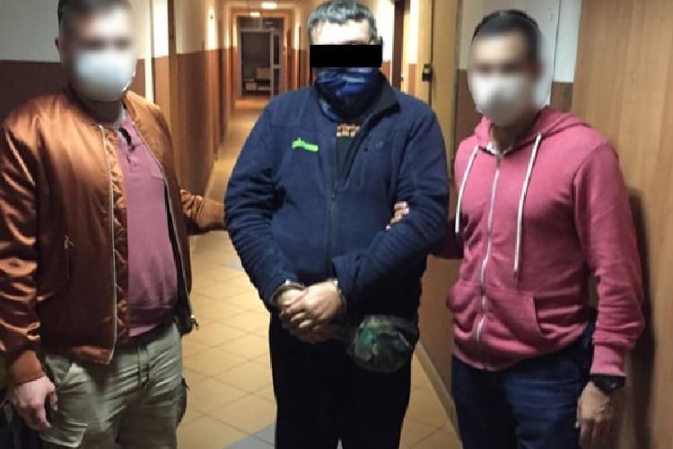 Trzech mężczyzn w kajdankach, aresztowanych za przestępstwo.