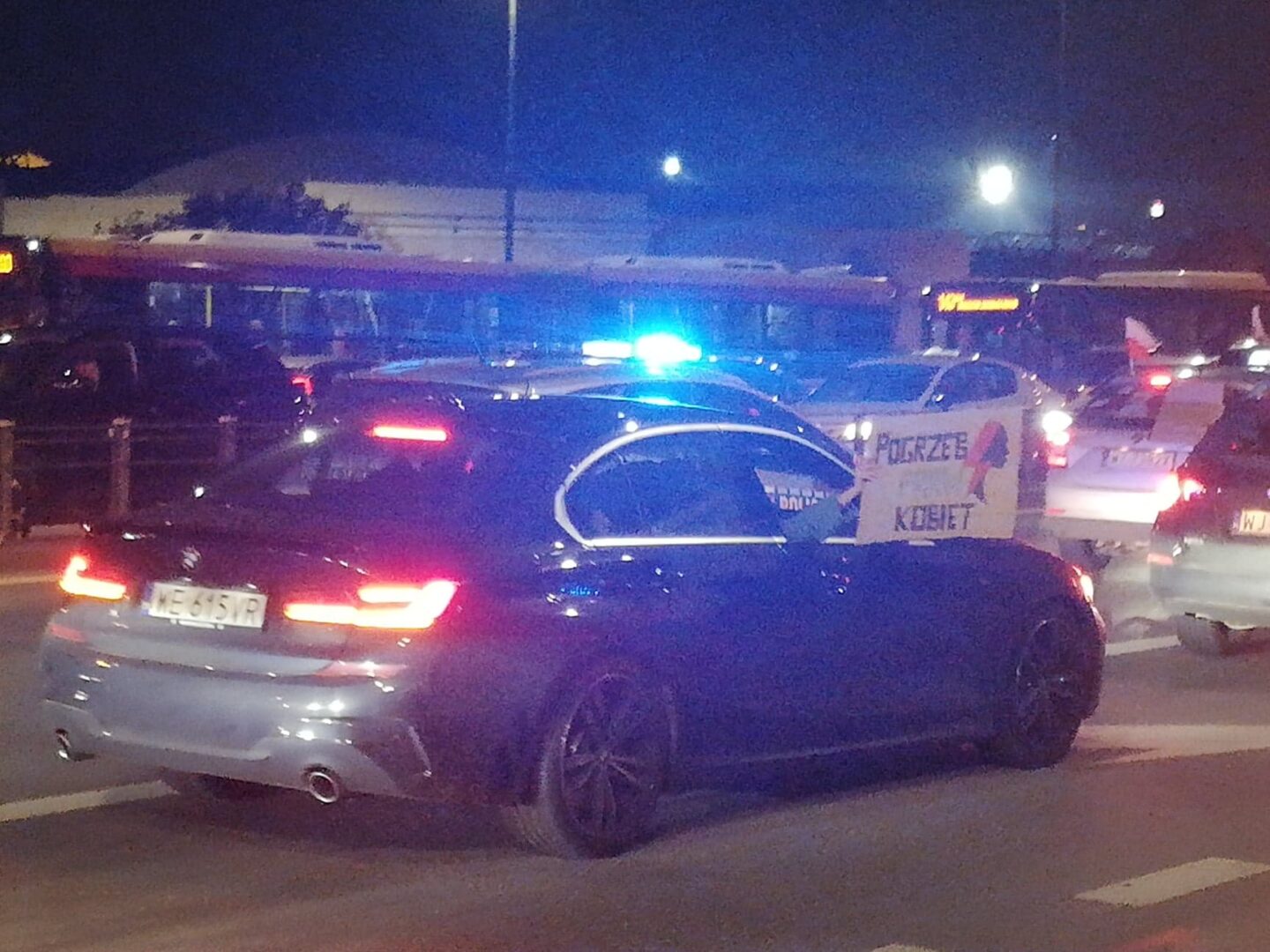 Protest samochodowy w nocy, na tablicy widnieje napis „Pogrzeb kobiet”