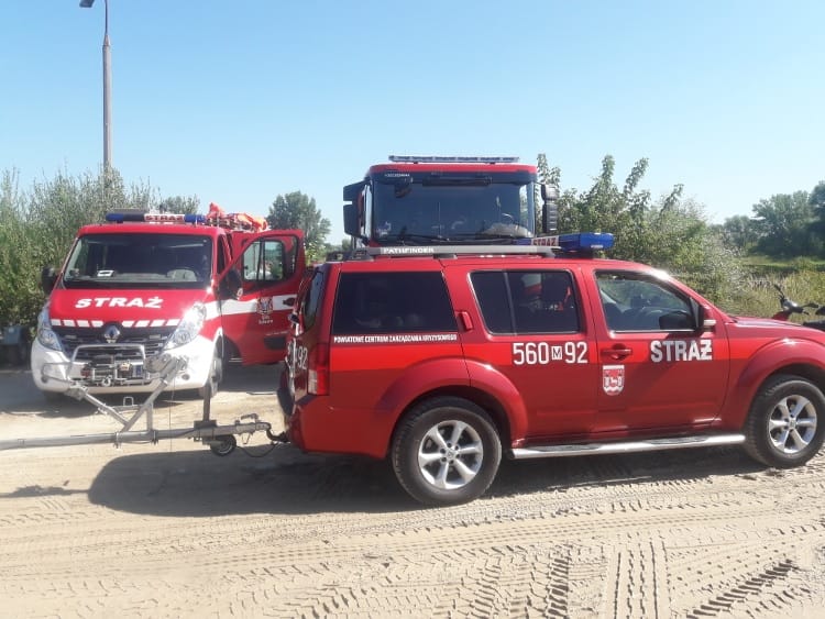 Trzy czerwone pojazdy polskiej straży pożarnej: van, SUV (560M 92) i większy samochód ciężarowy.