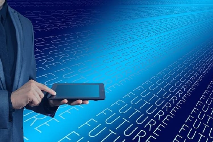 Przedsiębiorca korzysta z tabletu na futurystycznym tle z tekstem „przyszłość”.