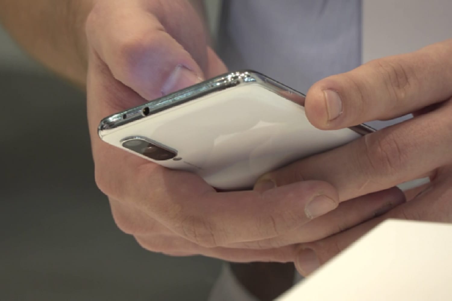 Zbliżenie dłoni trzymających biały smartfon