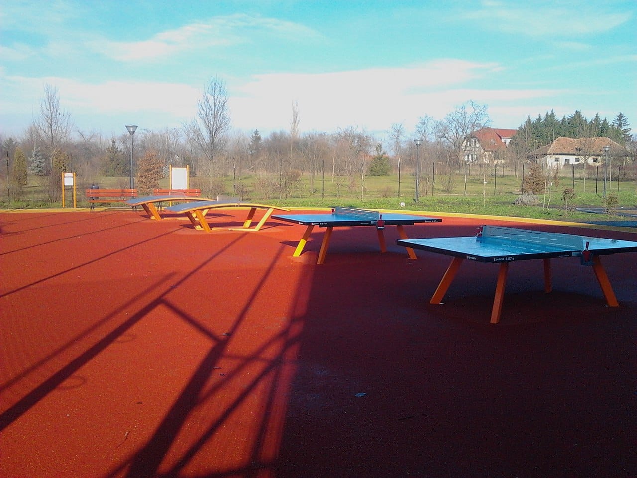 Stoły do ping-ponga na świeżym powietrzu na czerwonej powierzchni.