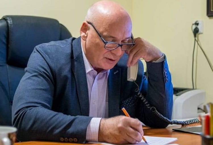 Biznesmen w garniturze rozmawiający przez telefon i robiący notatki