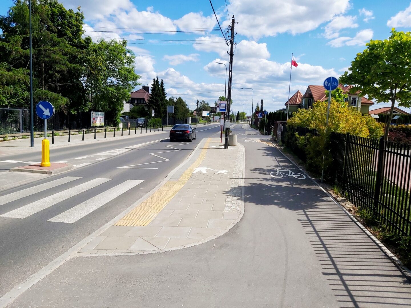 Ścieżka dla pieszych i rowerzystów z przejściem dla pieszych, ulicą i domami