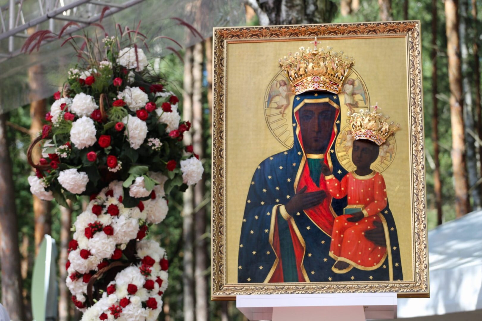 Ikona Czarnej Madonny z Dzieciątkiem w złotych koronach, otoczona kwiatami.