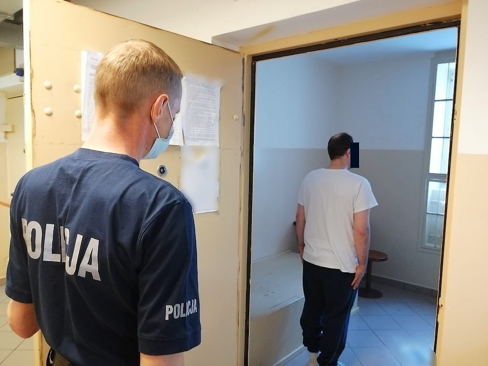 Policjant eskortujący więźnia do celi