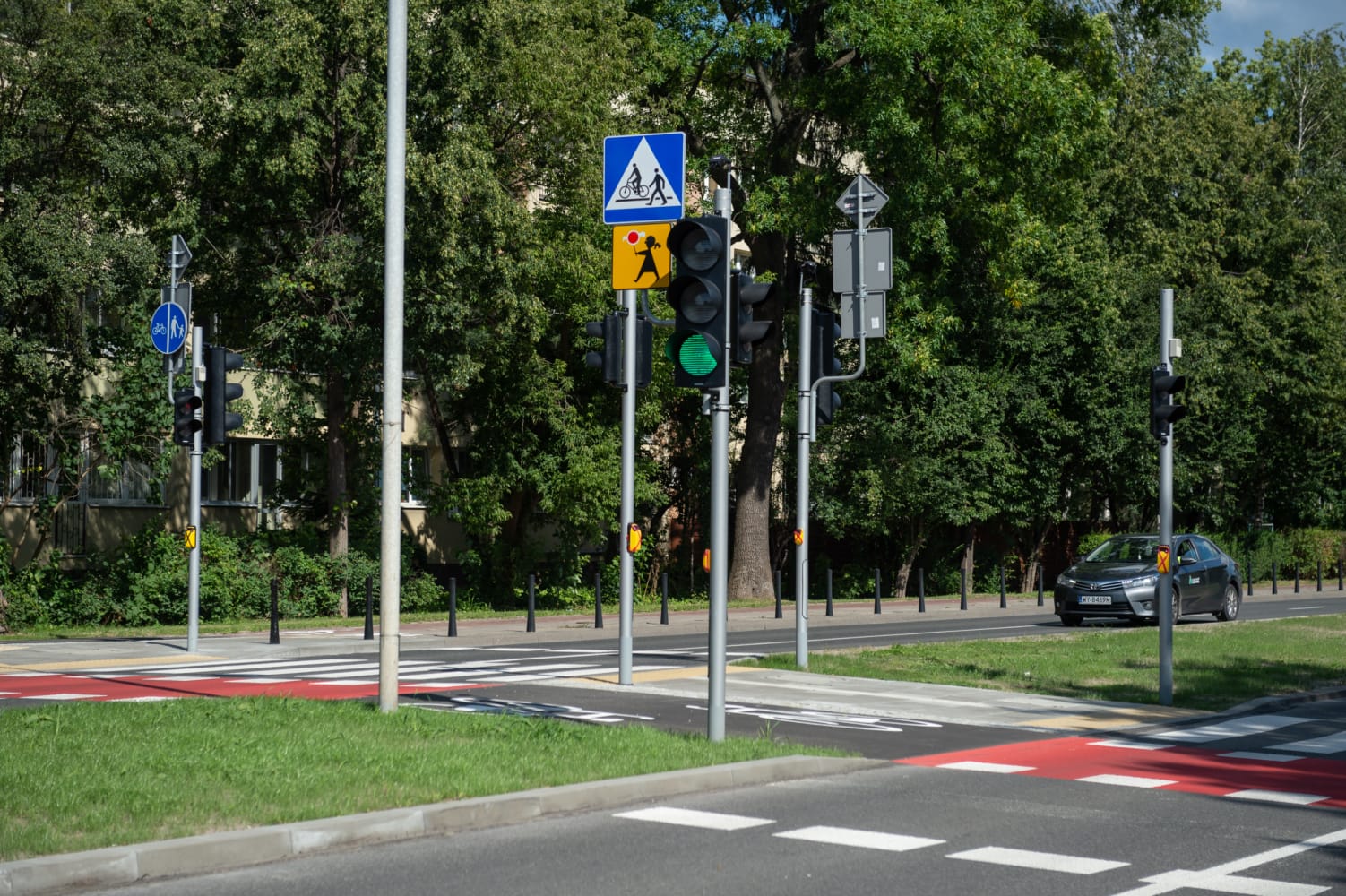 Przejście dla pieszych z sygnalizacją świetlną i znakami dla pieszych na skrzyżowaniu w mieście.
