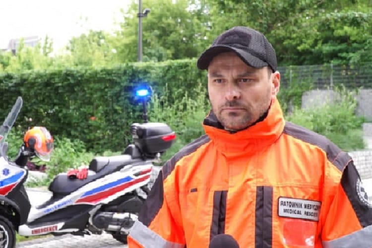 Ratownik medyczny w pomarańczowym mundurze mówi, w pobliżu znajduje się skuter ratunkowy