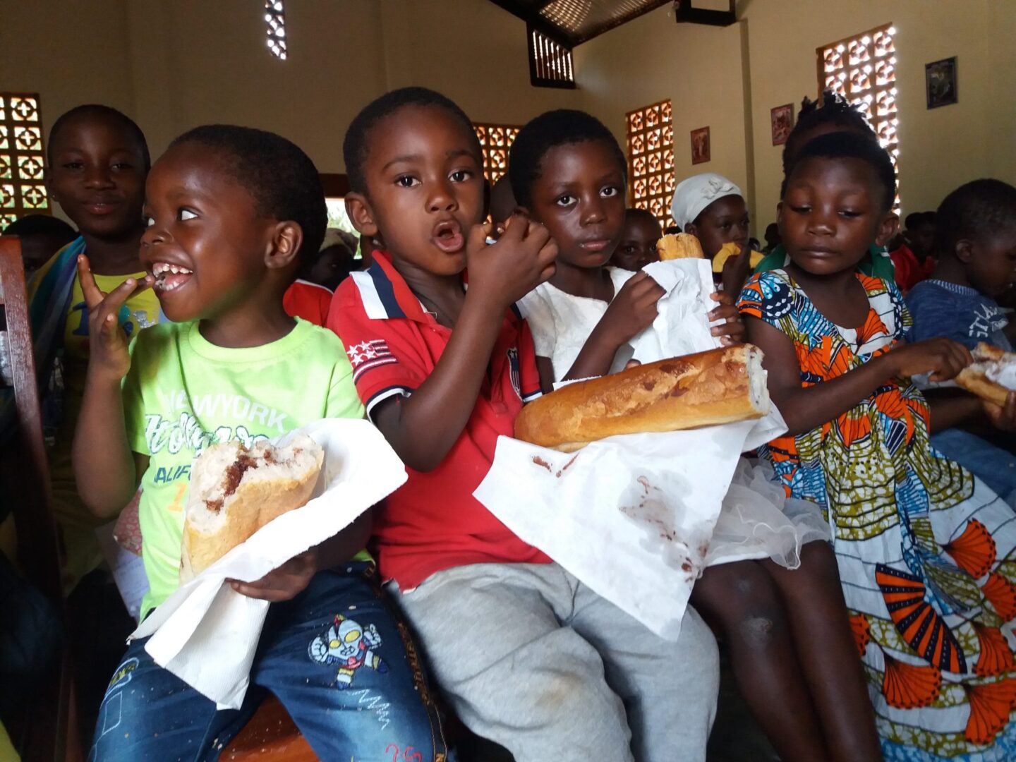 Szczęśliwe afrykańskie dzieci jedzą chleb i wspólny posiłek