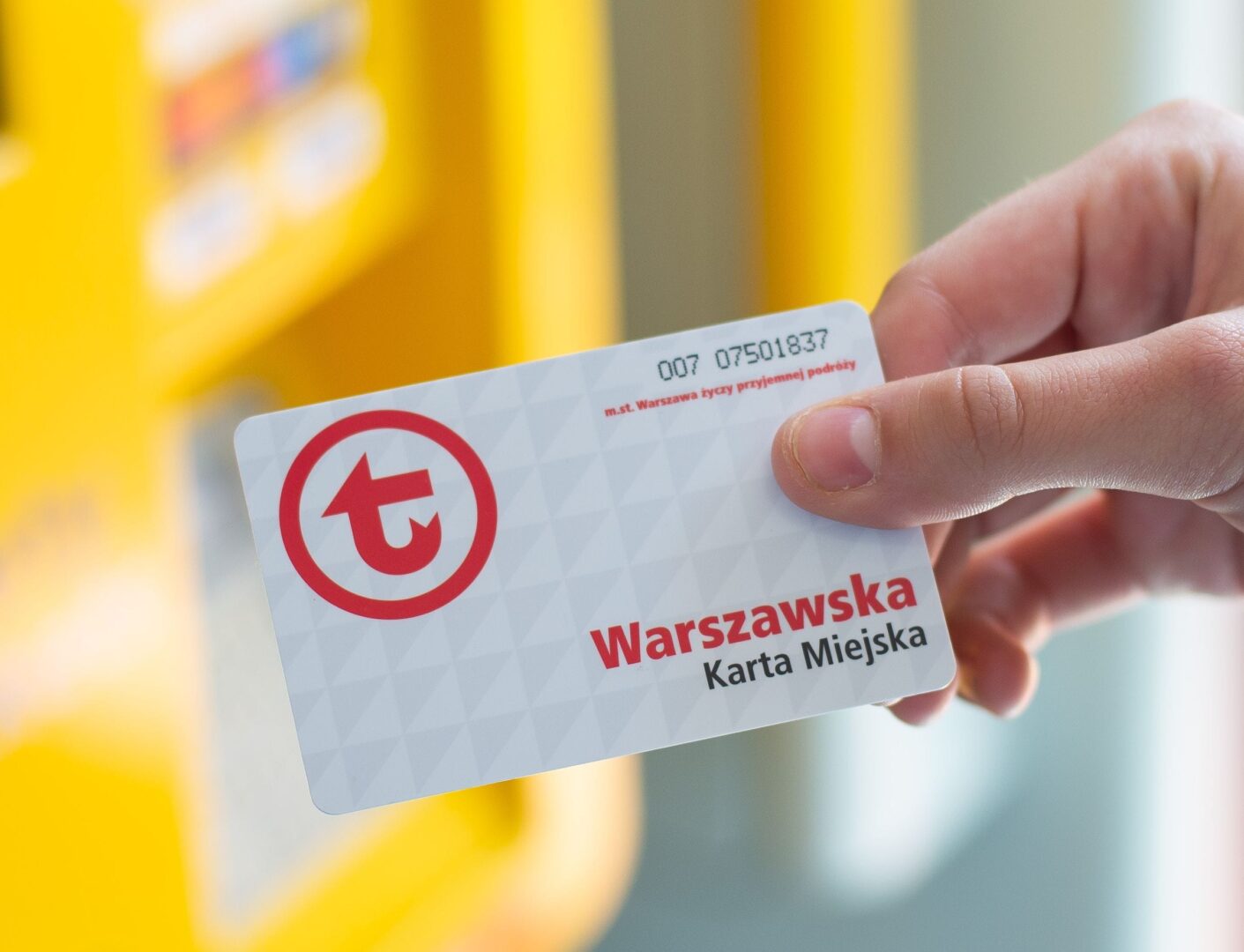 Ręka trzymająca Warszawską Kartę Miejską, na której widnieje numer karty 007 07501837.