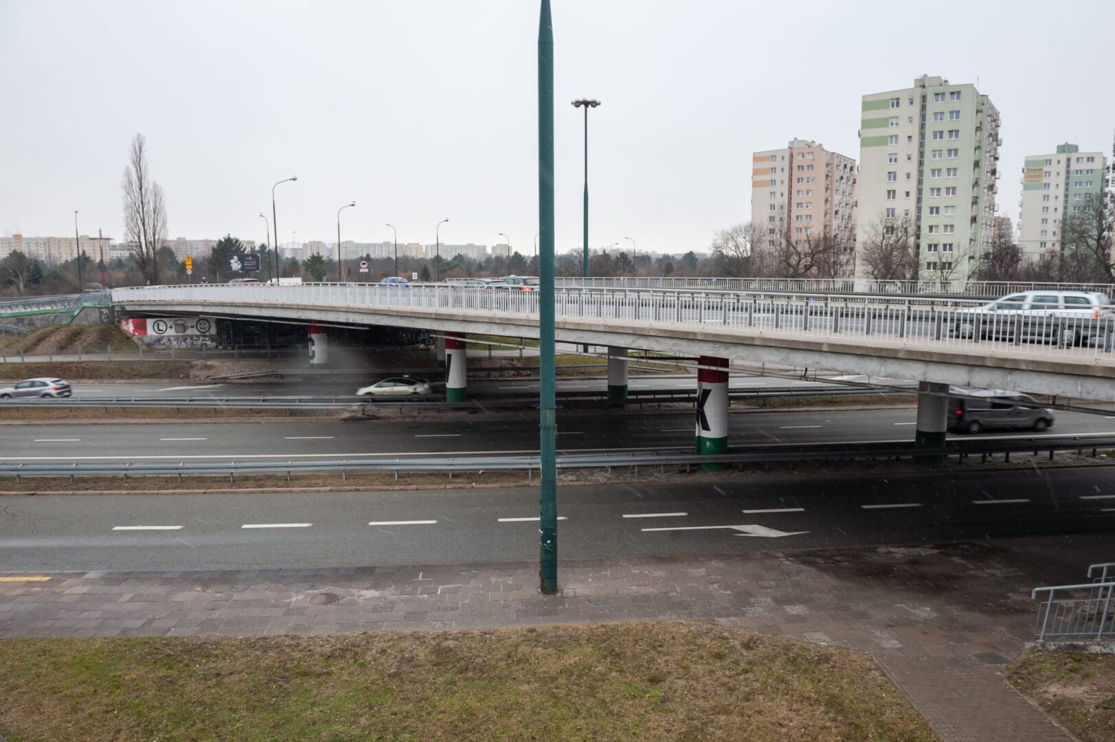 Wiadukt na Przyczółku Grochowskim. W tle ruch uliczny i zabudowania.
