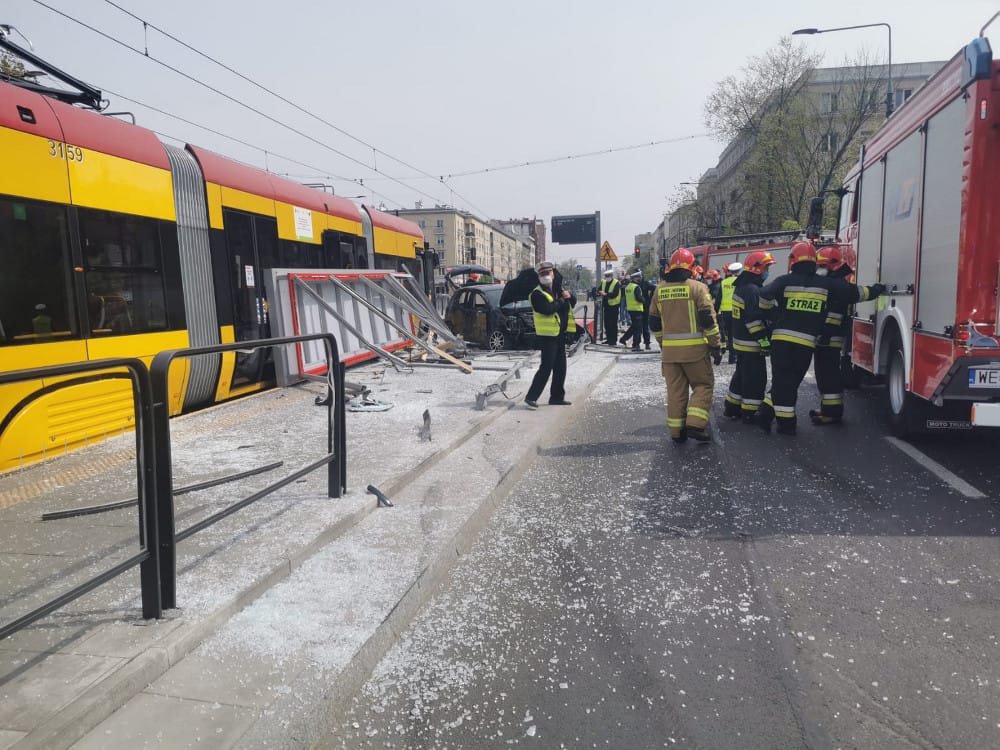 Skutki wypadku tramwajowego: strażacy i ratownicy na miejscu zderzenia samochodu z tramwajem.