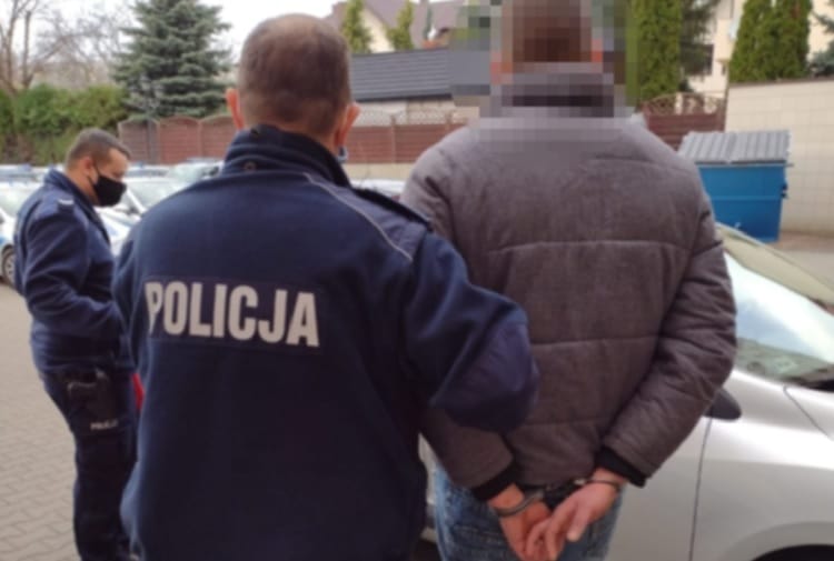 Policjant aresztujący podejrzanego z kajdankami. POLICJA