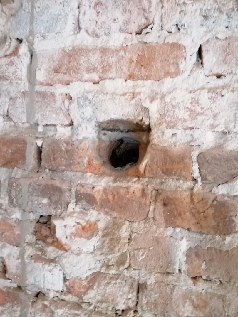 Zbliżenie otworu w starej ceglanej ścianie ze starą zaprawą.