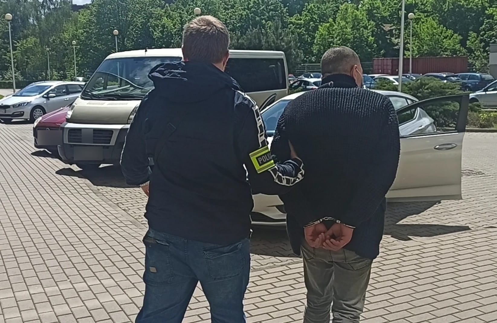 Policjant aresztujący podejrzanego w kajdankach