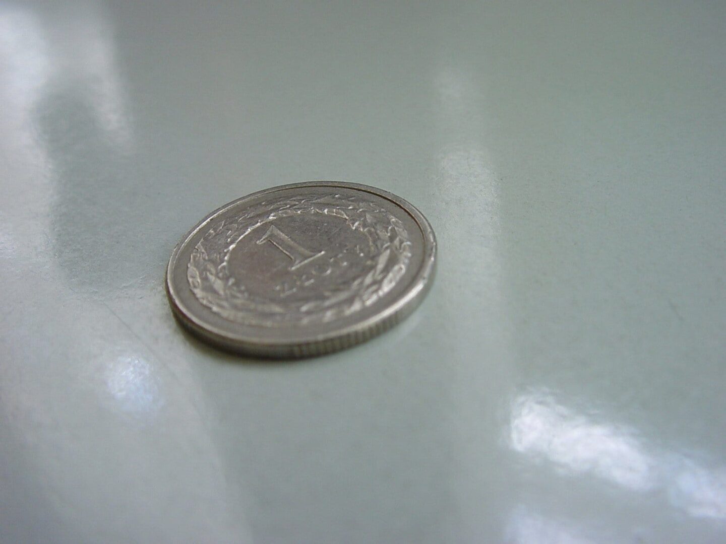 Jedna polska moneta złota na jasnej powierzchni