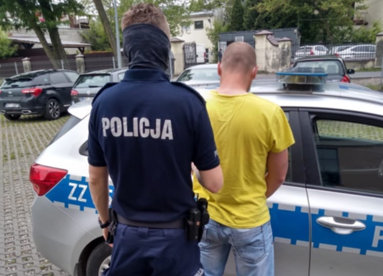 Policjant zatrzymujący podejrzanego. POLICJA