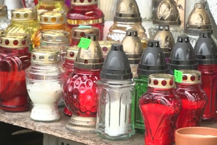 Asortyment kolorowych świec wotywnych i szklanych świeczników na Dzień Wszystkich Świętych.