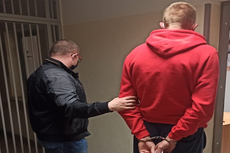 Policjant aresztujący podejrzanego w kajdankach