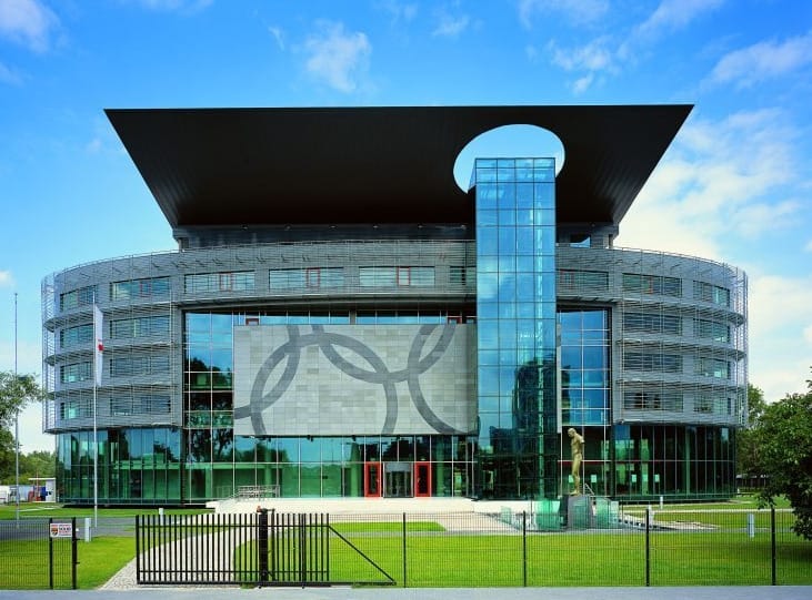 Nowoczesny budynek siedziby olimpijskiej ze szklaną fasadą i emblematem kół olimpijskich