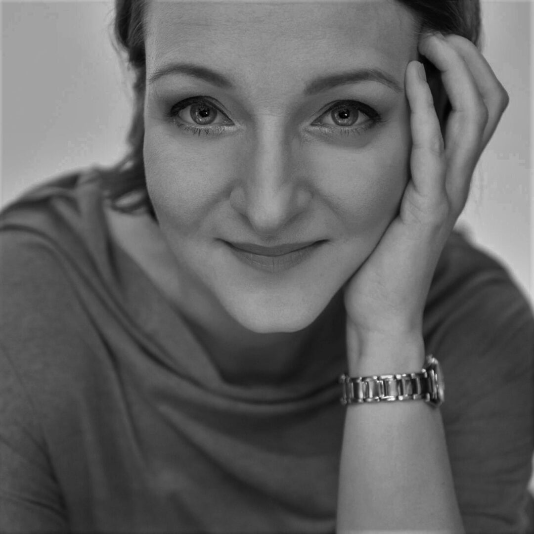 Czarno-biały portret kobiety, z ręką na twarzy.