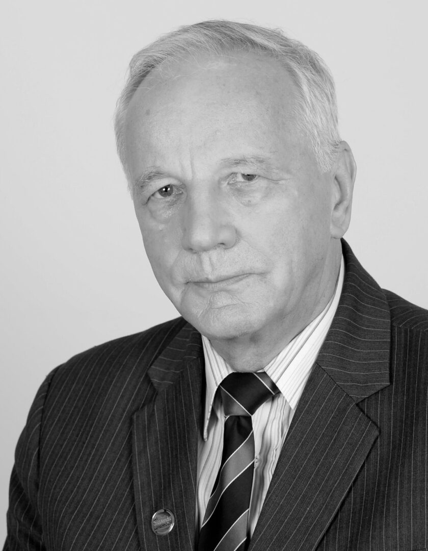 Portret starszego biznesmena w garniturze w prążki i krawacie.