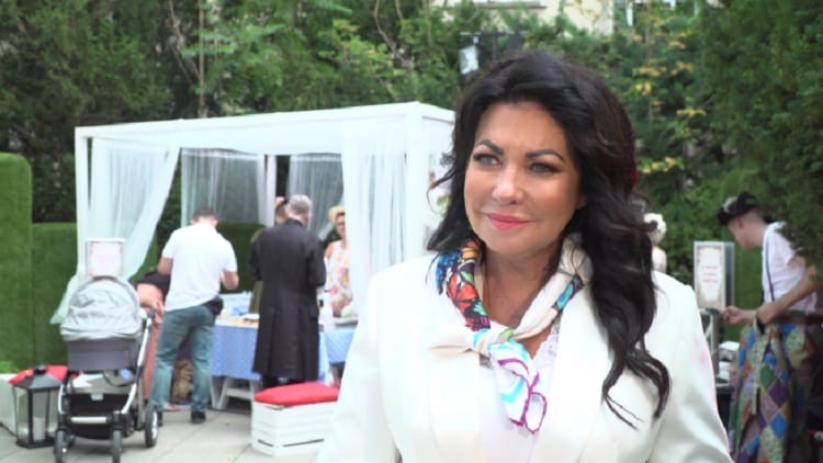 Kobieta w białym blezerze i kolorowym szaliku na imprezie plenerowej