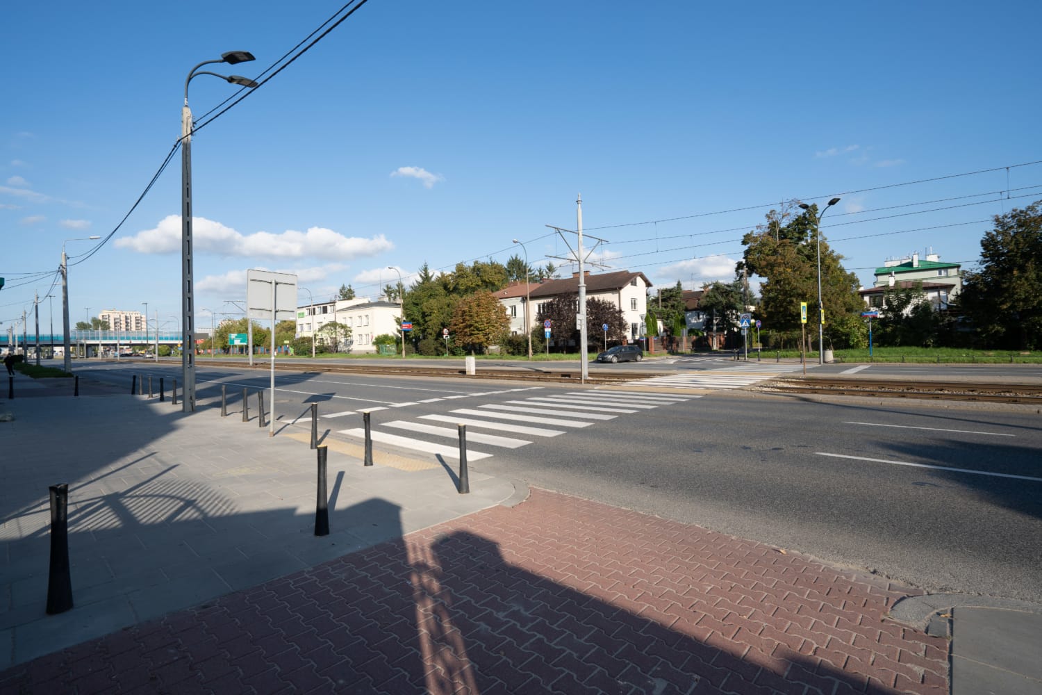 Przejście dla pieszych na ulicy miejskiej z budynkami i torami tramwajowymi
