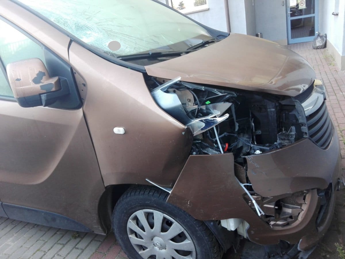 Uszkodzenie czołowe brązowego vana Opel Vivaro. Znaczne uszkodzenie reflektora i zderzaka.