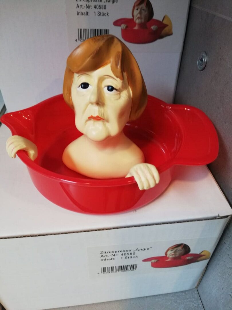 Czerwona wyciskarka do cytrusów w kształcie głowy Angeli Merkel