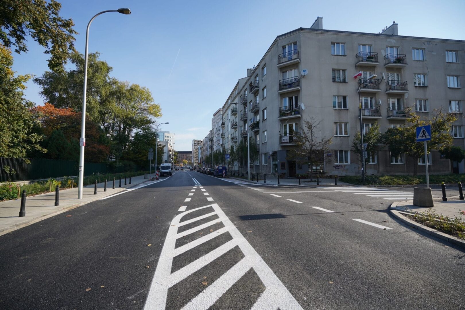 Pusta ulica miejska z budynkami mieszkalnymi w słoneczny dzień.