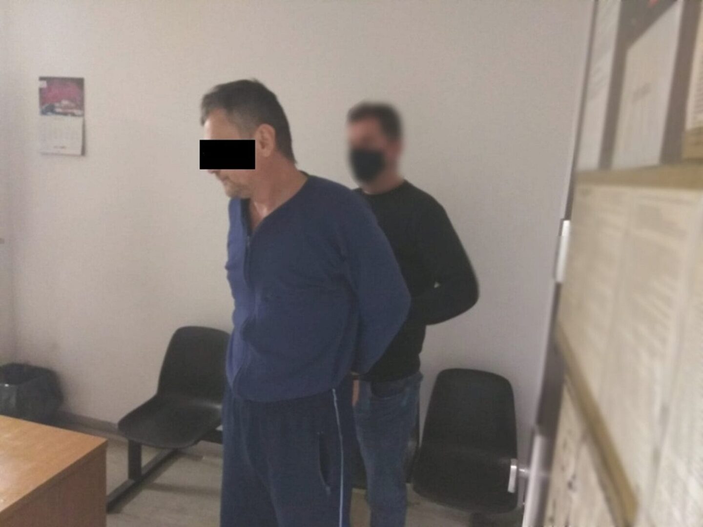 Zatrzymany mężczyzna w kajdankach z policjantem