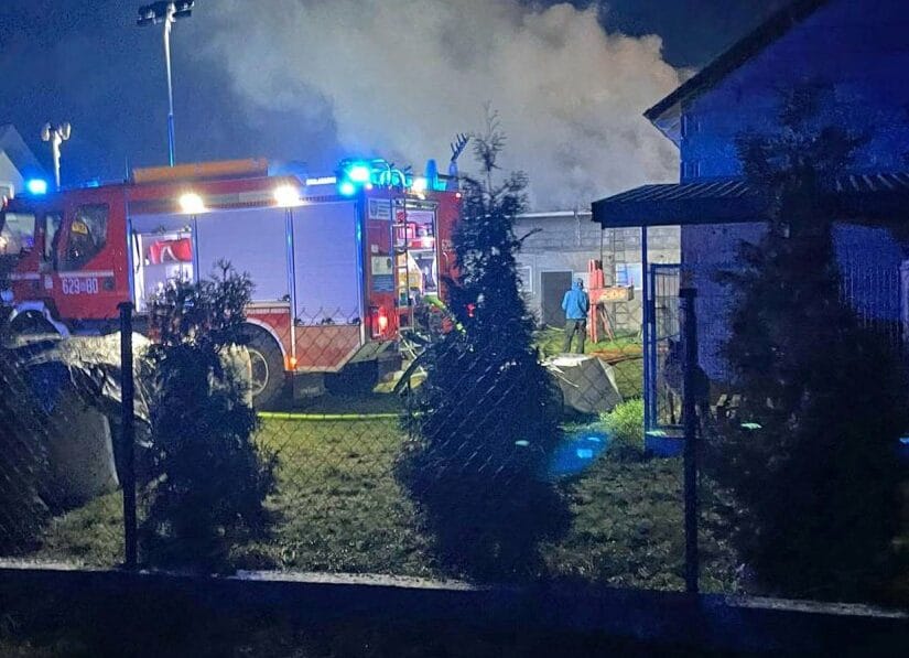 Strażacy walczący z dużym pożarem w nocy. Pojazd ratunkowy na miejscu zdarzenia.