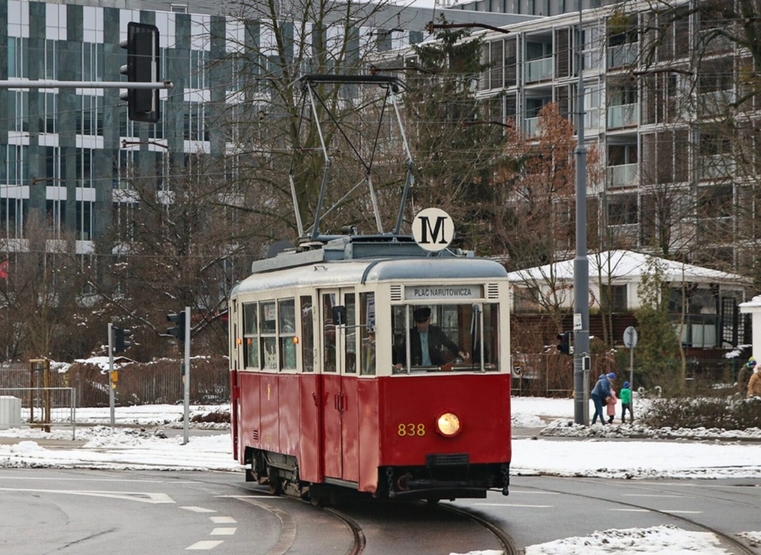 Stary, czerwony i kremowy tramwaj krakowski nr 838 na zaśnieżonej ulicy, linia M.