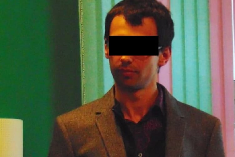 Mężczyzna w marynarce, z zasłoniętymi oczami