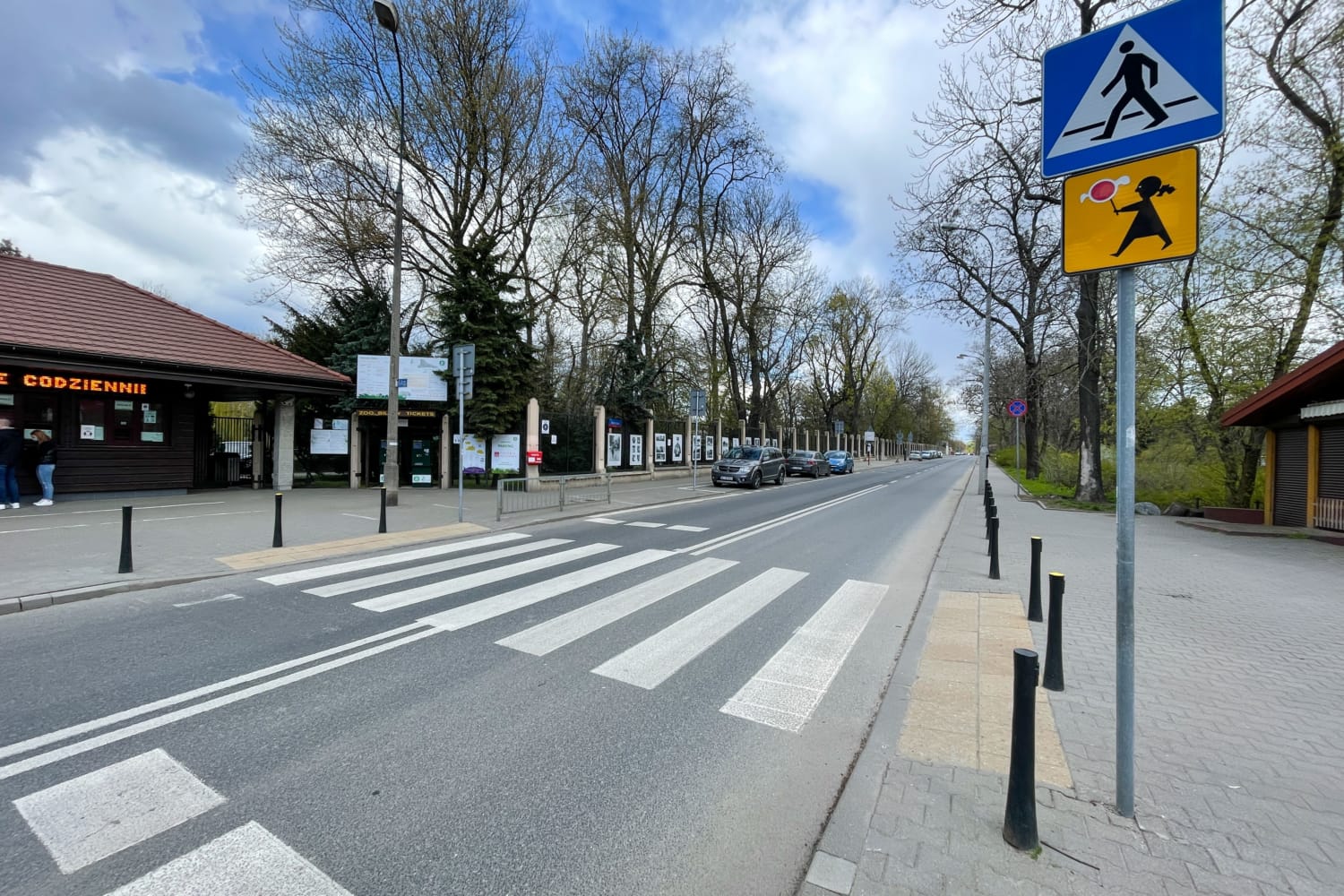 Przejście dla pieszych w pobliżu wejścia do zoo; widoczny znak „bilety” (bilety).