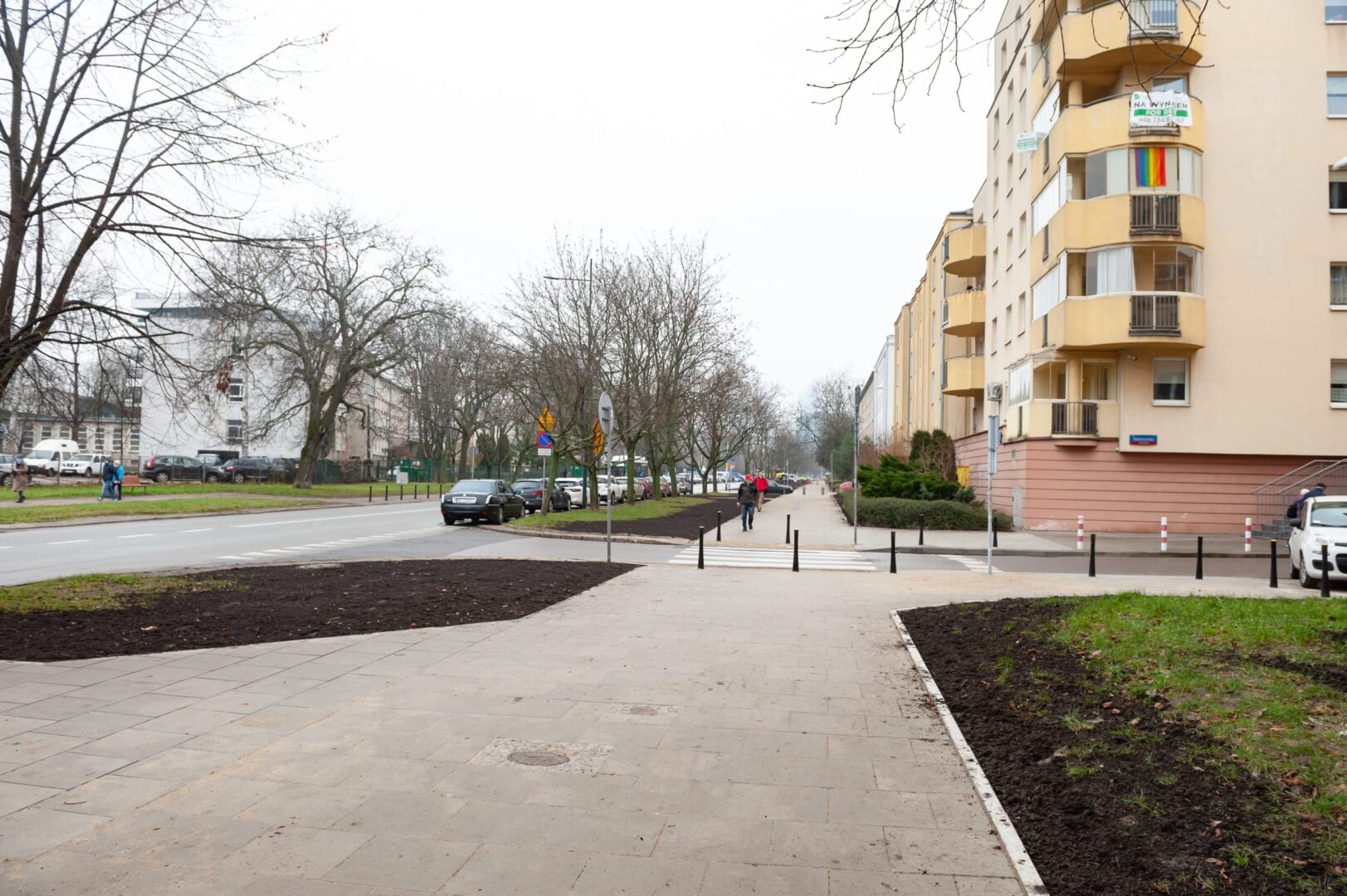 Scena uliczna i chodnik dla pieszych na osiedlu mieszkaniowym z budynkami mieszkalnymi.