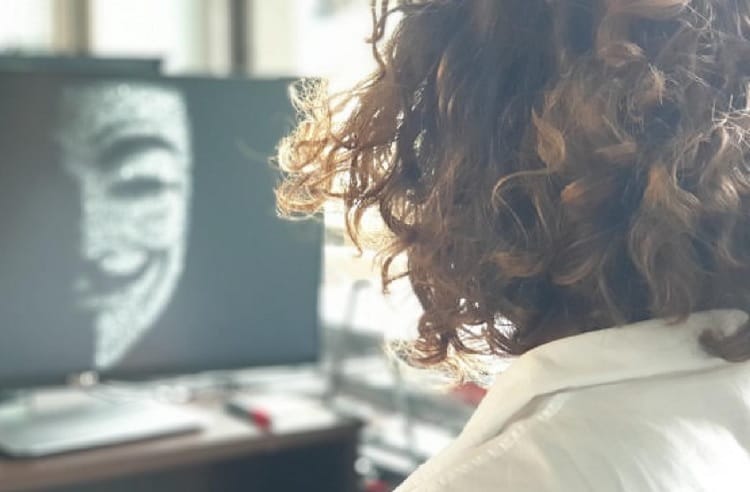 Kobieta oglądająca maskę Anonymous na ekranie komputera