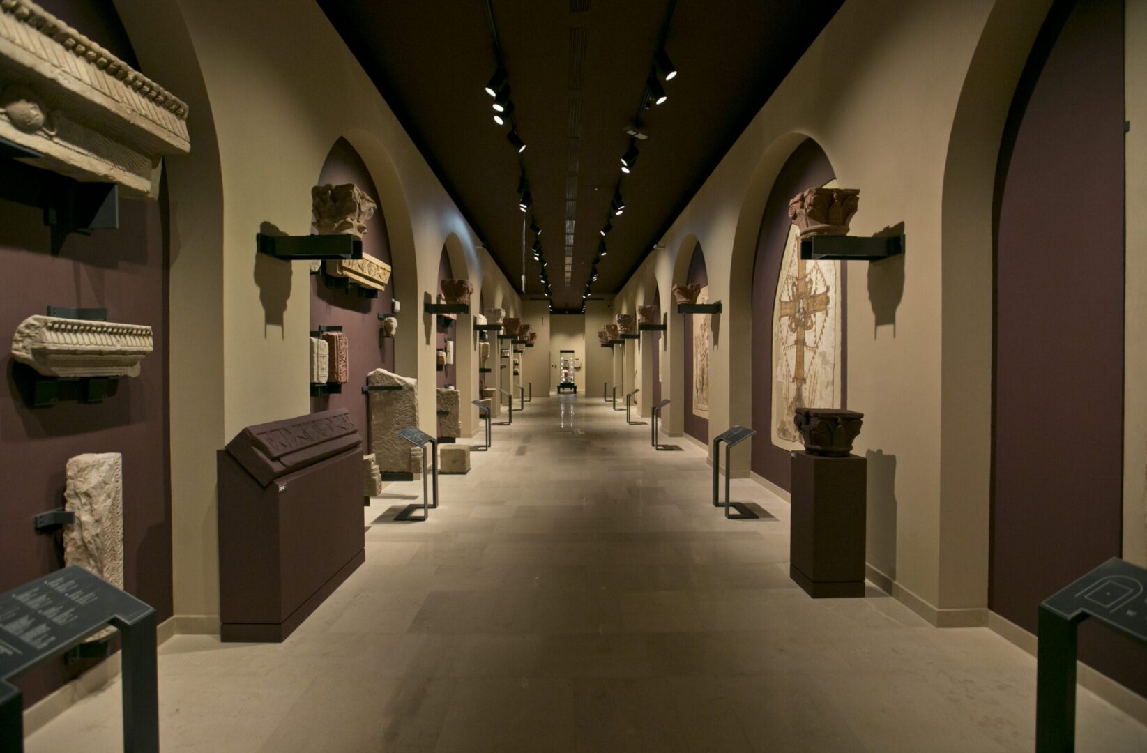 Korytarz muzeum ze starożytnymi rzymskimi artefaktami na ścianach.