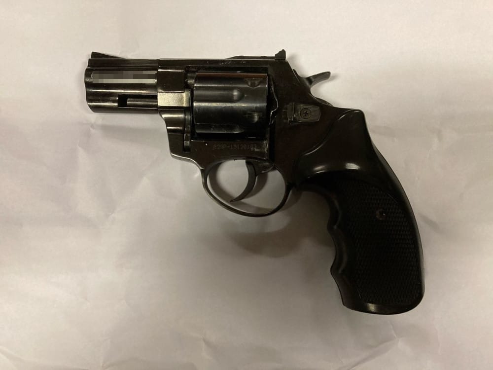 Czarny rewolwer na białym tle