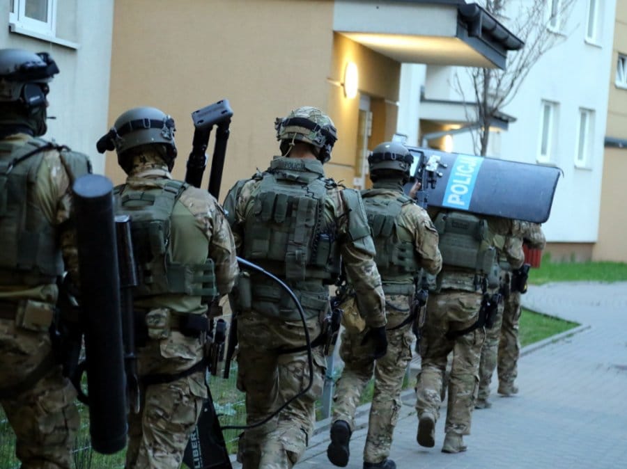 Oddział SWAT w stroju taktycznym przeprowadza nalot.