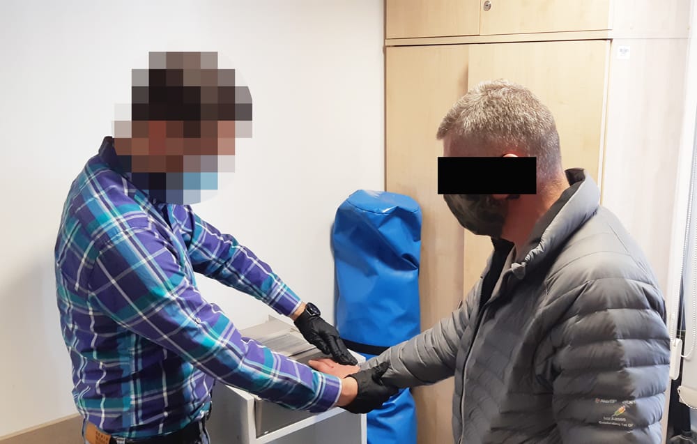 Policjant pobierający odciski palców od podejrzanego.