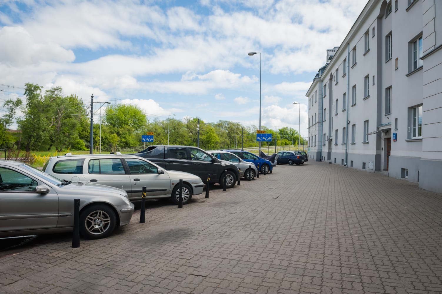 Samochody zaparkowane wzdłuż ulicy miejskiej obok budynku